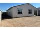 View of the house exterior showcasing large windows, a covered patio, and ample space for outdoor activities at 17683 W Odeum Ln, Goodyear, AZ 85338