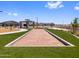 A bocce ball court is situated in a community park with nearby picnic tables, benches and landscaping at 17683 W Odeum Ln, Goodyear, AZ 85338