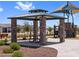 Community park featuring picnic tables under gazebo and a covered playground, with nearby benches for parents' relaxation at 17683 W Odeum Ln, Goodyear, AZ 85338