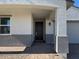 Inviting front entryway with a dark wood door and brick-paved porch at 17683 W Odeum Ln, Goodyear, AZ 85338