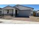 Single-story home featuring a two-car garage and a brick-paved driveway, offering an inviting curb appeal at 17683 W Odeum Ln, Goodyear, AZ 85338