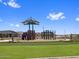 Well-maintained community playground features turf, covered play structures and open play spaces under a clear blue sky at 17683 W Odeum Ln, Goodyear, AZ 85338