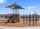 A play area with a climbing structure and shade is located in a community park with houses in the background at 17683 W Odeum Ln, Goodyear, AZ 85338
