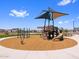 Community playground featuring slides, climbing structures, and play equipment surrounded by wood chips at 17683 W Odeum Ln, Goodyear, AZ 85338