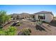 Backyard featuring desert landscaping with a covered patio, outdoor seating, and a built-in firepit at 18961 N 259Th Ave, Buckeye, AZ 85396