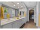 Bright bathroom with double sinks, vanity, walk-in closet and stylish fixtures with coordinated yellow towels at 18961 N 259Th Ave, Buckeye, AZ 85396