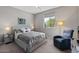 Inviting bedroom with plush carpet, stylish mirrored nightstands, a cozy chair, and ample natural light at 18961 N 259Th Ave, Buckeye, AZ 85396