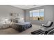 Serene bedroom with a large window offering desert views, complemented by cozy seating and modern decor at 18961 N 259Th Ave, Buckeye, AZ 85396