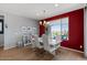 Well-lit dining area with a modern table and chairs, complemented by red accent wall at 18961 N 259Th Ave, Buckeye, AZ 85396