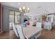 Bright dining room featuring a modern table, contemporary chandelier, and seamless access to the outdoor patio at 18961 N 259Th Ave, Buckeye, AZ 85396