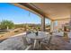 Covered outdoor patio with dining area and fireplace, perfect for enjoying desert views at 18961 N 259Th Ave, Buckeye, AZ 85396
