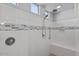 Modern walk-in shower featuring white tiled walls, a built-in bench, and decorative mosaic accents at 18961 N 259Th Ave, Buckeye, AZ 85396