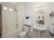 Bright bathroom with a shower-tub combination, pedestal sink, and decorative mirror at 19824 N Valencia Ct, Surprise, AZ 85374