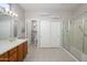 Bright bathroom with double sink vanity, tile flooring, and a glass-enclosed shower at 19824 N Valencia Ct, Surprise, AZ 85374