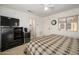 Cozy bedroom features a plaid bedspread, ceiling fan, and a TV with cabinet at 19824 N Valencia Ct, Surprise, AZ 85374