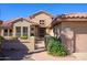 Welcoming front entrance with security gate, desert landscaping, and charming architectural details at 19824 N Valencia Ct, Surprise, AZ 85374