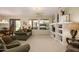 Spacious living room featuring neutral carpet, a ceiling fan, and built in shelving at 19824 N Valencia Ct, Surprise, AZ 85374