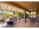 Spacious covered patio area with dining furniture, heater, and verdant surroundings at 19824 N Valencia Ct, Surprise, AZ 85374