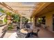 Beautiful covered patio with string lights, dining table, and desert landscaping at 19824 N Valencia Ct, Surprise, AZ 85374