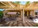 Charming outdoor patio with pergola cover, swing, dining table, and gas heater at 19824 N Valencia Ct, Surprise, AZ 85374