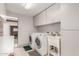 Bright laundry room with machines, sink, and ample cabinet space at 2107 N Campo Allegre Dr, Tempe, AZ 85288