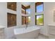 Bright bathroom features a soaking tub next to multi-window at 24548 N 121St Pl, Scottsdale, AZ 85255
