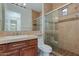 Bathroom with a tiled walk-in shower, warm colors, modern vanity, and decorative lighting at 24548 N 121St Pl, Scottsdale, AZ 85255