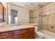 Bathroom vanity with a tan marble countertop and a glass-enclosed shower at 24548 N 121St Pl, Scottsdale, AZ 85255