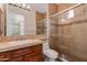 Tiled bathroom featuring a glass shower, wood vanity, and modern lighting at 24548 N 121St Pl, Scottsdale, AZ 85255