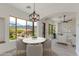 Inviting dining area with views and a round table next to a living room space bathed in natural light at 24548 N 121St Pl, Scottsdale, AZ 85255