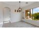 Dining area with wood floors, modern chandelier, and large windows with backyard views at 24548 N 121St Pl, Scottsdale, AZ 85255