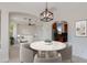 Well-lit dining space with a round table and living room views, adjacent to an open kitchen at 24548 N 121St Pl, Scottsdale, AZ 85255