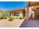 Stylish home exterior featuring a spiral staircase, desert landscaping, and a paved patio area at 24548 N 121St Pl, Scottsdale, AZ 85255
