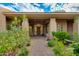 Inviting front entrance with a wooden door, lush plants, and a brick walkway leading to the home at 24548 N 121St Pl, Scottsdale, AZ 85255