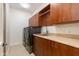 Well-equipped laundry room includes cabinetry, sink, counter space, and modern washer/dryer units at 24548 N 121St Pl, Scottsdale, AZ 85255