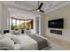 Serene bedroom with a tray ceiling, a fireplace, a sitting area, and scenic outdoor views through large windows at 24548 N 121St Pl, Scottsdale, AZ 85255