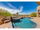 Sparkling pool with rock waterfall feature and desert views creates a serene outdoor oasis at 24548 N 121St Pl, Scottsdale, AZ 85255