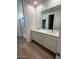 Bathroom featuring dual vanity, white cabinets and a glass-enclosed shower at 25430 W Graham Trl, Buckeye, AZ 85326
