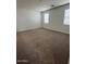 Spacious bedroom filled with natural light from two windows and neutral carpet at 25430 W Graham Trl, Buckeye, AZ 85326