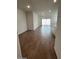 Spacious living room with wood-look tile flooring leading to a sliding glass door at 25430 W Graham Trl, Buckeye, AZ 85326