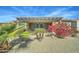 Beautiful backyard with covered patio, lush flowering bushes, and desert landscaping at 26439 W Covey Ln, Buckeye, AZ 85396
