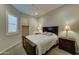 Bedroom featuring a wooden bed frame, lamps, and a large window at 26439 W Covey Ln, Buckeye, AZ 85396