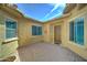 Private courtyard featuring a tiled patio, stucco walls, and windows with blue shutters at 26439 W Covey Ln, Buckeye, AZ 85396