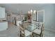 Stylish dining area connected to the kitchen, featuring a glass table and modern chandelier at 26439 W Covey Ln, Buckeye, AZ 85396