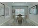 Bright dining area with a glass table, a chandelier, and plantation shutters at 26439 W Covey Ln, Buckeye, AZ 85396