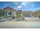 Charming single-story home featuring a stone facade, desert landscaping, and a paver driveway at 26439 W Covey Ln, Buckeye, AZ 85396