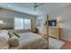 Elegant main bedroom with a luxurious four-poster bed, wood floors, and a ceiling fan at 26439 W Covey Ln, Buckeye, AZ 85396
