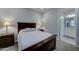 Bedroom with a wooden bed frame, lamps, and a bathroom en suite at 26439 W Covey Ln, Buckeye, AZ 85396