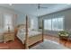 Comfortable main bedroom featuring a four-poster bed, ceiling fan, and shutters for natural light control at 26439 W Covey Ln, Buckeye, AZ 85396