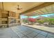 Covered patio featuring a stone fireplace, ceiling fan, and desert landscaping at 26439 W Covey Ln, Buckeye, AZ 85396